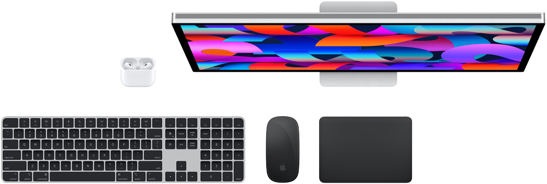 Accessoires Mac vus d’en haut : Studio Display, AirPods, Magic Keyboard, Magic Mouse et Magic Trackpad